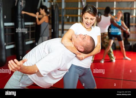 Woman practising neck grabbing move in gym Stock Photo - Alamy