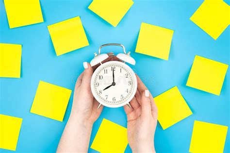 White Alarm Clock And Yellow Paper Reminder Flat Lay Stock Photo