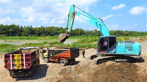 Excavator Digging Loading Dirt Into Dump Trucks From The River Kobelco