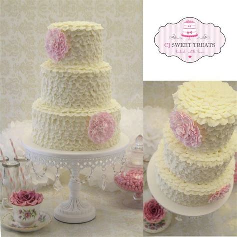 Three Tiered Wedding Cake With Pink Flowers On Top And White Frosting