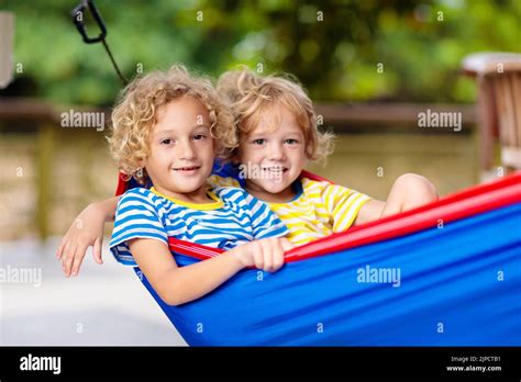 Chico relajándose en hamaca Los niños juegan en el jardín de verano en