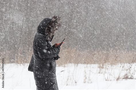 Cold Weather And Blizzard In City Park Woman In Fur Hood Standing With