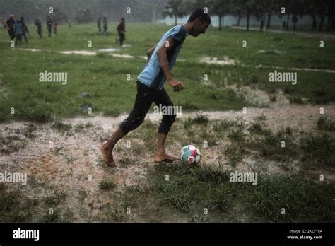 Boys play football during rain at a park in Dhaka, Bangladesh on June 11, 2021. (Photo by Syed ...