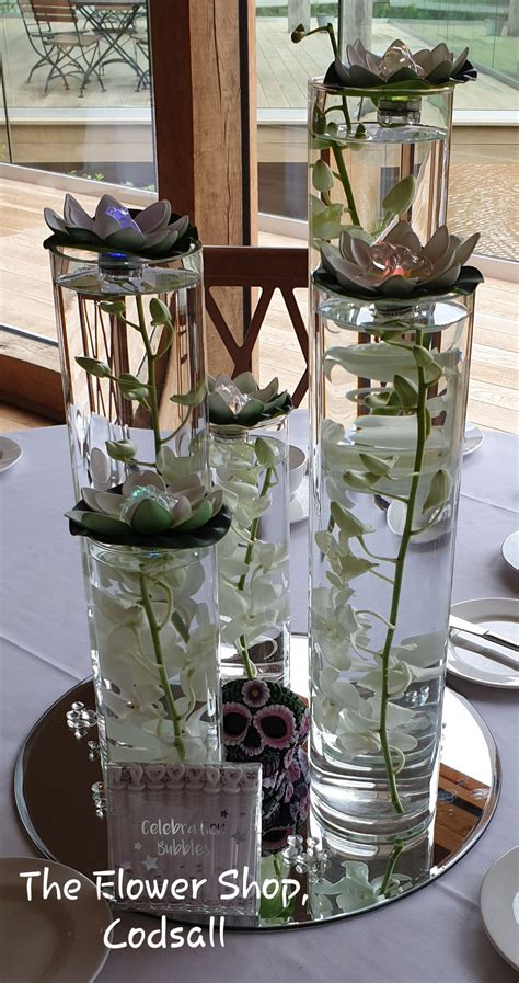 Flowers Include Dendrobium Orchids Submerged In Cylinder Vases With