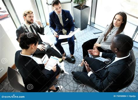 Group Of Five Young People Discussing Something While Sitting At The