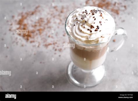 Glass Of Cold Coffee Covered With Whipped Cream On Grey Table Stock