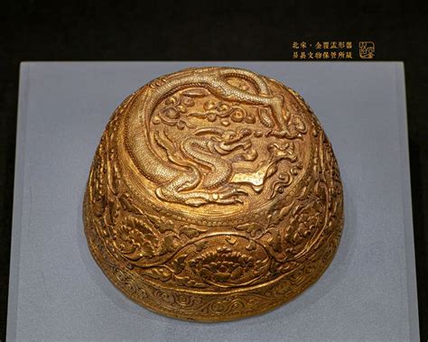 An Ornately Decorated Gold Bowl On Display In A Museum Case With