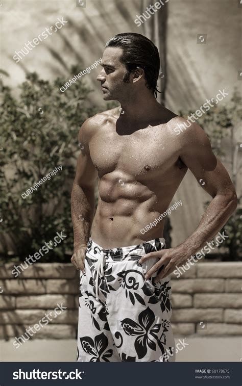 Stylized Portrait Of A Beautiful Muscular Wet Male Model Outdoors In