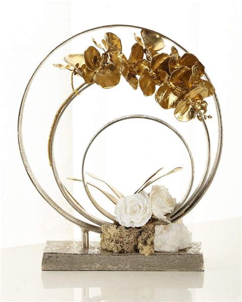 A Metal Sculpture With Flowers And Rocks In It