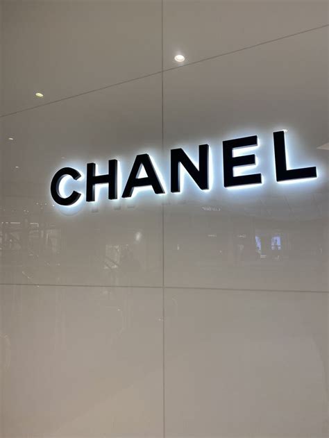 A Chanel Store Front With The Word Chanel Lit Up