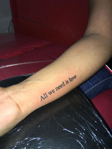 A Person With A Tattoo On Their Arm Saying All We Need Is Love