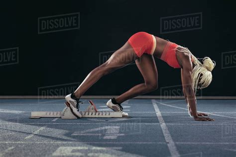 Female Athlete Taking Position On Her Marks To Start Off The Run Side