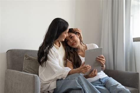 Casal De Lésbicas Feliz Se Abraçando Usando Tablet Digital Relaxando No