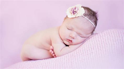 Beautiful Cute Child Baby Is Sleeping On Pink Cloth In Light Purple