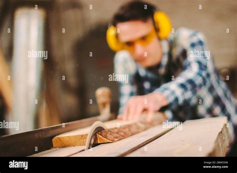 Professional Carpenter Using Sawing Machine For Cutting Wooden Board At