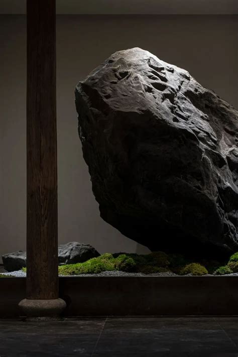 A Large Rock Sitting In The Middle Of A Room With Moss Growing On It S