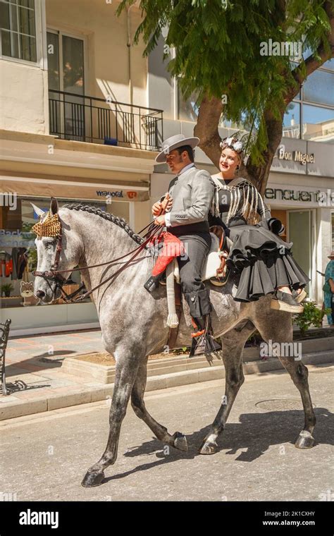 Men and women in traditional spanish costumes horseback riding during ...