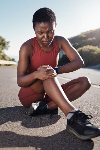 Joelho de mulher negra e lesão esportiva no asfalto dor devido a