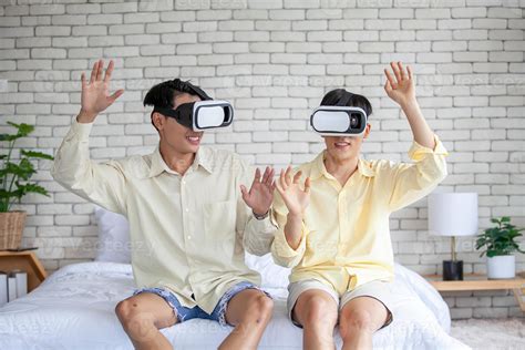 Asian gay couple wearing VR headset while playing together, LGBTQ ...