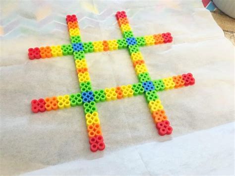 A Cross Made Out Of Legos Sitting On Top Of A Piece Of White Paper