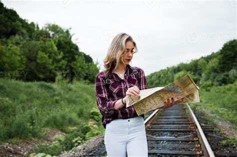 Portrait D Une Jolie Fille Blonde En Chemise Tartan Marchant Sur Le Chemin De Fer Avec Une Carte