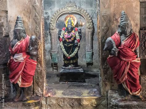 Alcove With Hindu Deity Statue In Wall With Guardian Statues Wrapped In