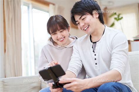 スマートフォンでゲームをするカップル 写真素材 7284520 フォトライブラリー Photolibrary