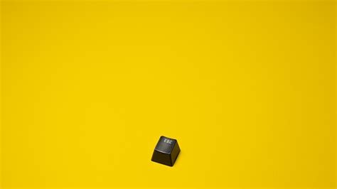 Premium Photo | A black keyboard sits on a yellow background.