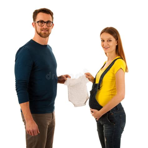 Happy Pregnant Woman And Man Holding Babys Dress Isolated Over W Stock