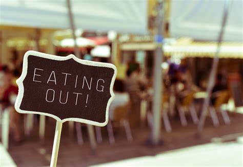 Chalkboard With The Text Eating Out In The Terrace Of A Restaurant