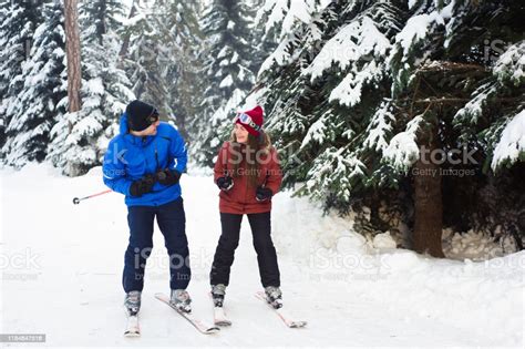 Happy Married Couple Skiing At A Ski Resort In The Forest Stock Photo