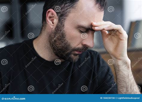 Handsome Bearded Man With Closed Eyes Holding Hand Near Forehead Stock