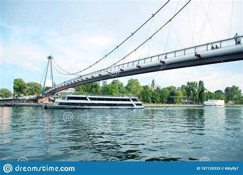 Tourist Pleasure Boat Under A Graceful Suspension Bridge Over The Wide