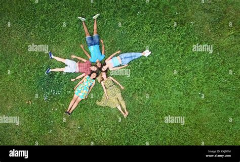 Group of young adults laying in grass in star formation Stock Photo - Alamy