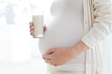 Pregnant Woman Touching Tummy With Milk Photograph By Ian Hooton