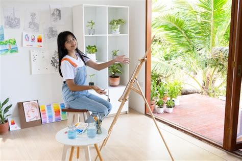 Niña pintando sobre papel en casa marco de maderahobby y estudio de