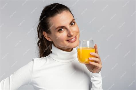 Premium Photo Beautiful Young Woman Drinking A Glass Of Orange Juice