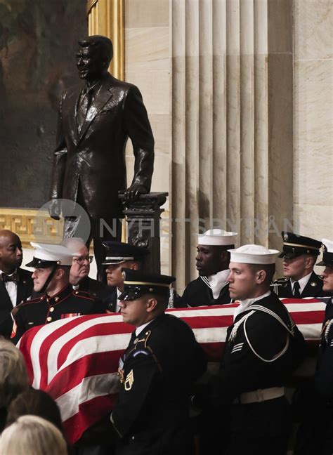 Military Honor Guard Carries Bush Casket Past Reagan Statue During