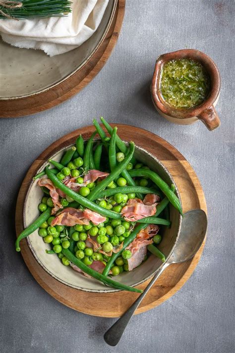 A Plate With Peas And Ham On It Next To A Small Bowl Of Green Beans