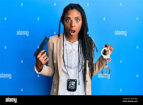 African American Police Woman Holding Gun And Handcuffs Afraid And