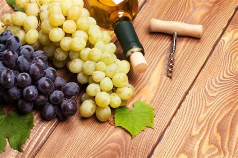 Garrafa De Vinho Branco E Cacho De Uvas Foto Premium