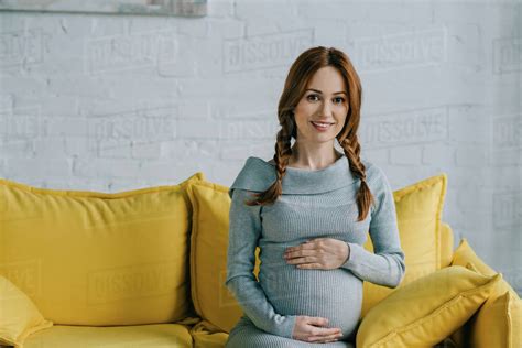 Attractive Pregnant Woman Touching Belly And Looking At Camera In