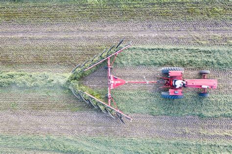 Farmer Driving Tractor Pulling Hay Rake Machine · Free Stock Photo