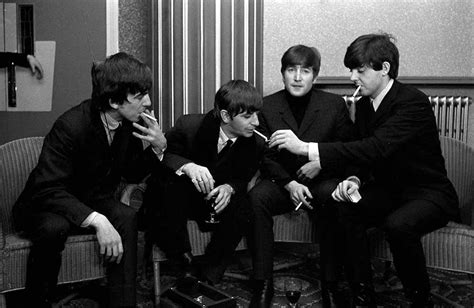 Members Of The Beatles Pop Group All Wearing Suits And Smoking