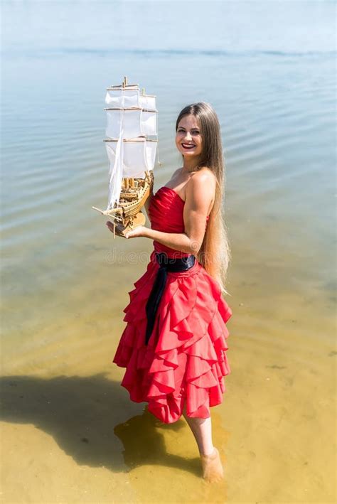 Woman in Red Dress Holding Boat Model on the Beach Stock Image - Image ...