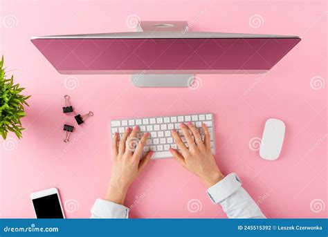 Female Hands Using Modern Computer With Business Accessories On Pink