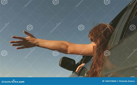 Hand From Car Window Catches The Wind Girl With Long Hair Is Sitting