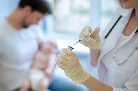 Médico se preparando para administrar uma injeção a um paciente Foto