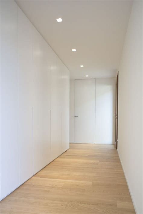 An Empty Room With White Walls And Wooden Floors Is Seen In This Image