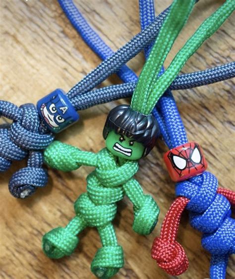 Three Spiderman Toys Are Tied Together On A Wooden Table With Blue